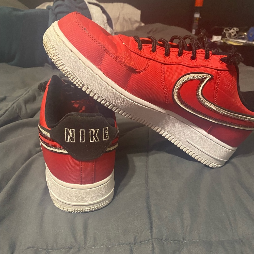 Mens 9.5 red and black nike air shoes.  Small fray line shown in picture.